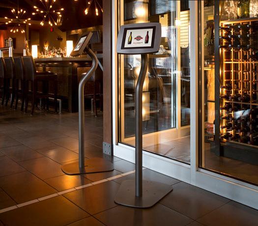 Two tall gooseneck-style Armodilo FLOOR tablet stands displaying wine menu images at the entrance of a bar or wine shop